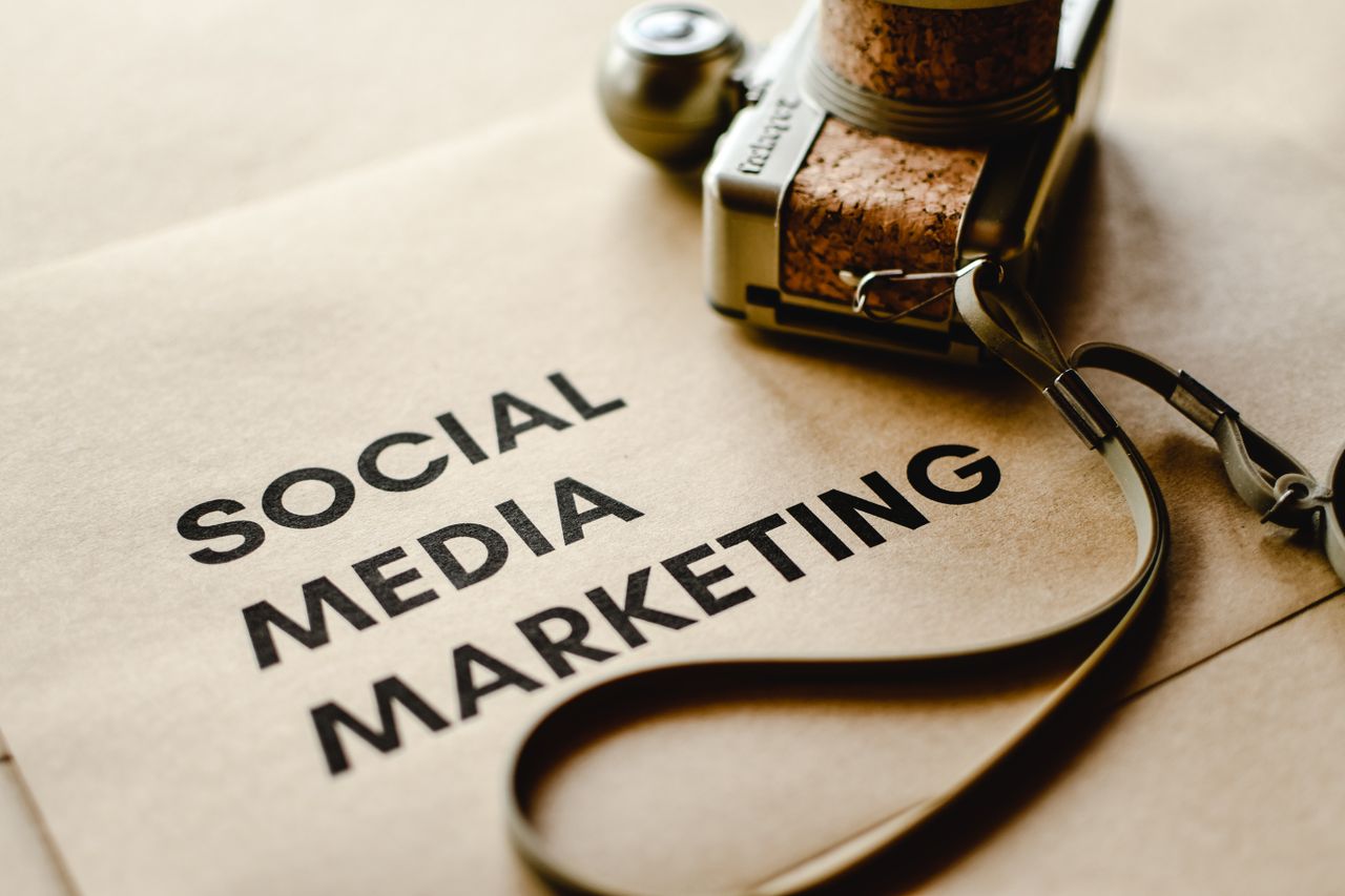 home-services-02 Close-up of a camera placed on brown paper with Social Media Marketing text, emphasizing digital marketing themes.
